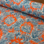 A close-up of patterned fabric with a bright orange background and blue toile-style tropical and scenic print, with one rolled section showing the material drape.

THE DRESSMAKER FABRICS 